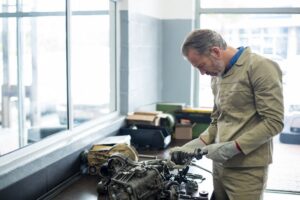mechanic repairing car transmission